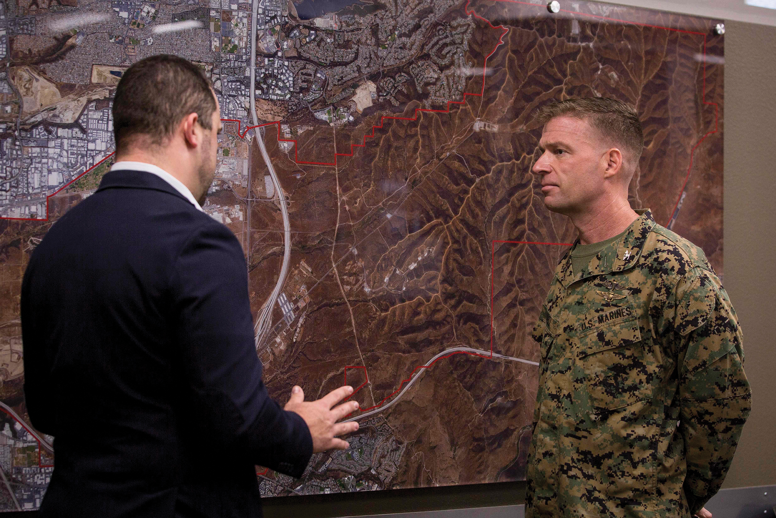 Marine Corps Colonel Thomas M. Bedell and Mick Wasco discuss microgrid and its benefits at station’s Energy and Water Operations Center