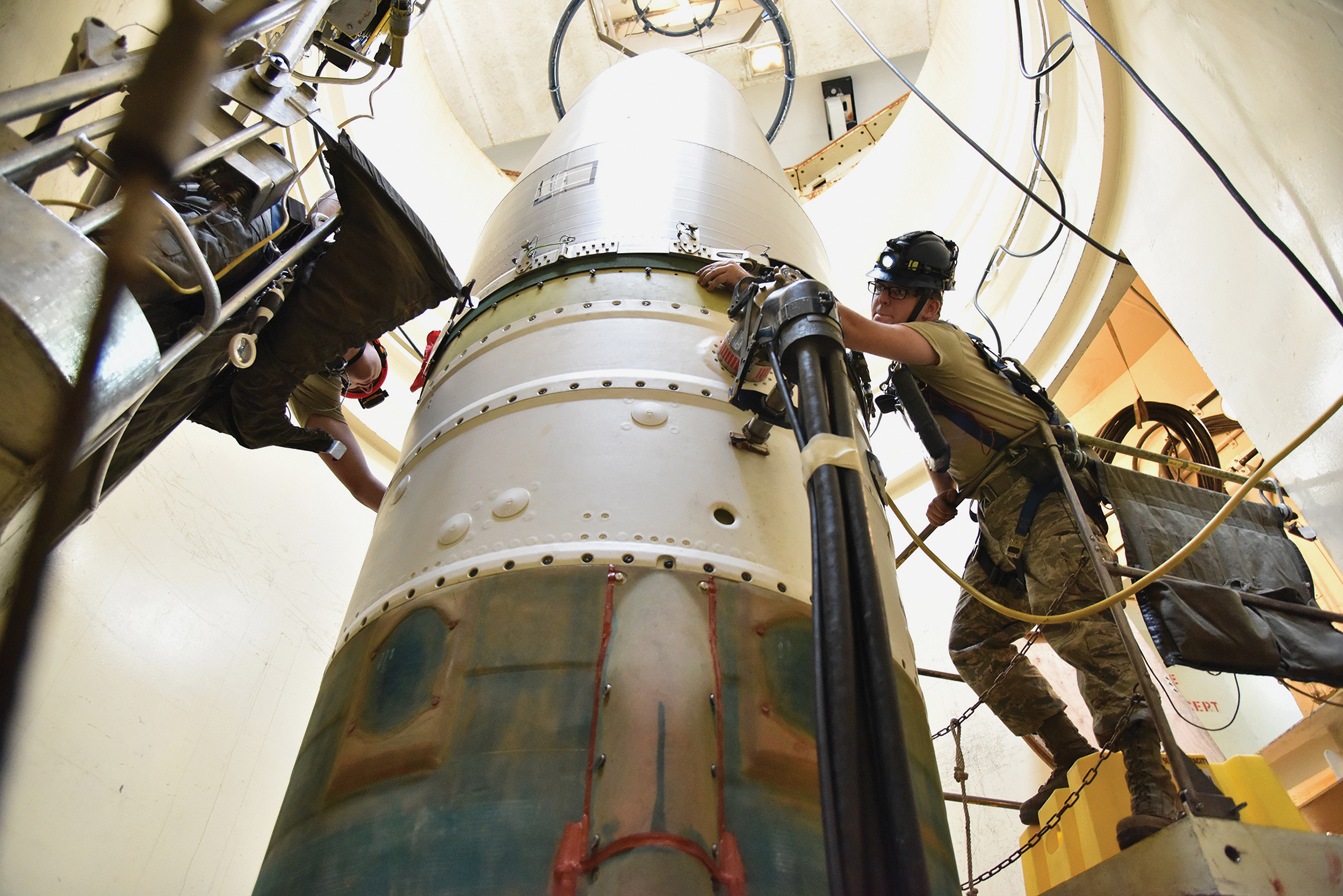 Airman 1st Class Jackson Ligon, left, and Senior Airman Jonathan Marinaccio, 341st Missile Maintenance Squadron technicians, connect reentry system to spacer on intercontinental ballistic missile during simulated electronic launch Minuteman test, September 22, 2020, at launch facility near Great Falls, Montana