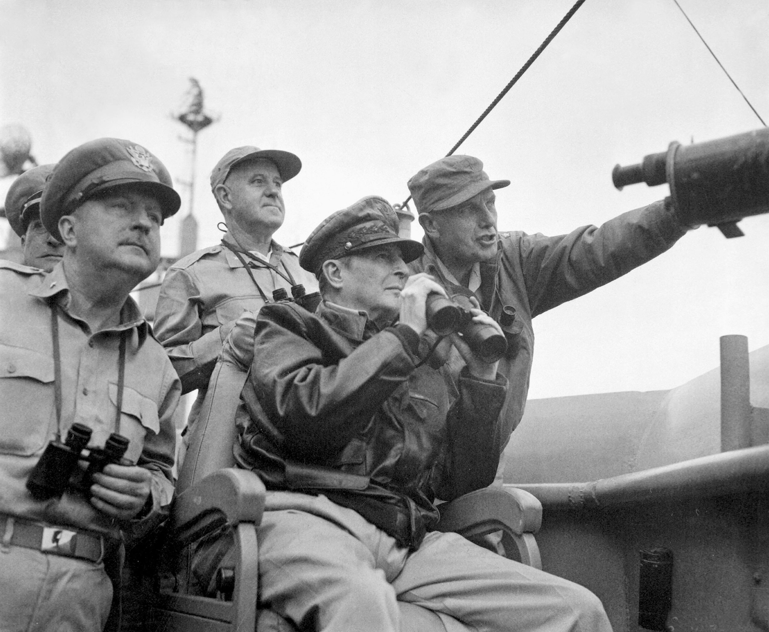 Brigadier General Courtney Whitney; General Douglas MacArthur, Commander-in-Chief, United Nations Command; and Major General Edward M. Almond observe shelling of Inchon from USS Mount McKinley
