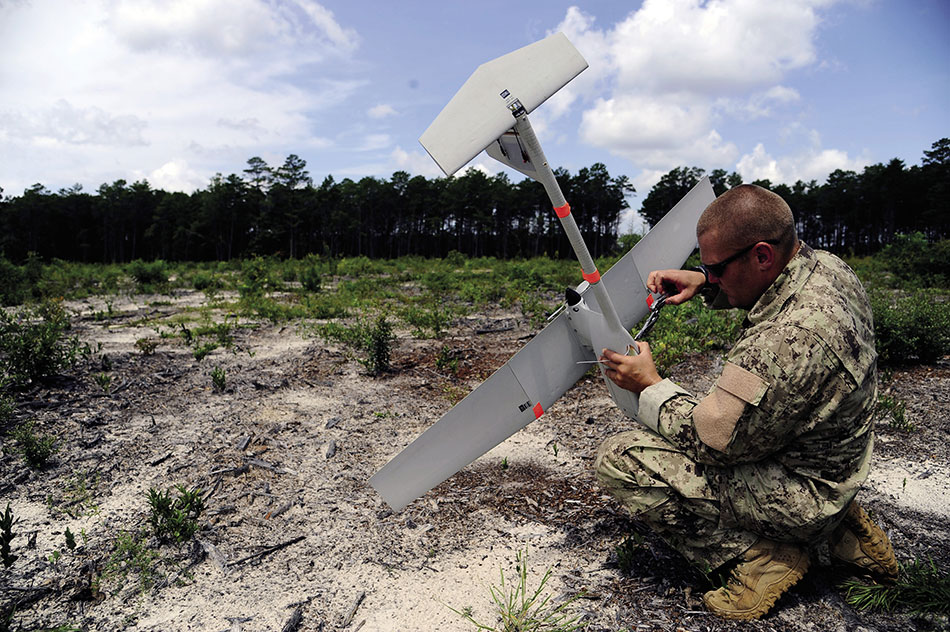 Airman fastens GPS mechanism inside RQ-11B Raven B hand-launched remote-controlled unmanned aerial vehicle (U.S. Air Force/Gustavo Castillo)
