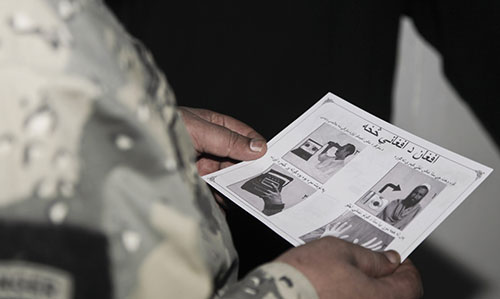 Border police at Wesh review information flier about Afghan 1000 Biometrics Facility (U.S. Army/Joseph Johnson)