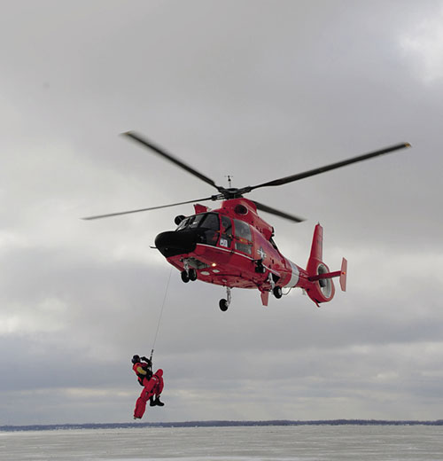 U.S. Coast Guard rescue swimmer deploys from MH-65C Dolphin during mass rescue exercise Icy Resolve 2013 (U.S. Coast Guard)
