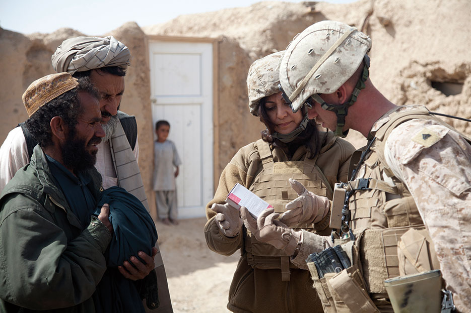 Marine Corps linguist for Female Engagement Team 11-2, Task Force Leatherneck, explains how to care for wound at district center in Delaram, Nimroz Province, Afghanistan (U.S. Marine Corps/Catie D. Edwards)