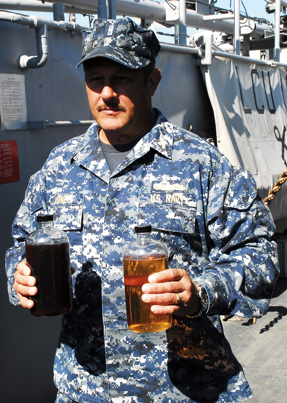 Sailor presents samples of traditional F-76 diesel fuel and 50/50 biofuel blend to illustrate use of biofuels in support of Navy Secretary’s goal to cut petroleum consumption in half by 2015 (U.S. Navy/Lolita Lewis)