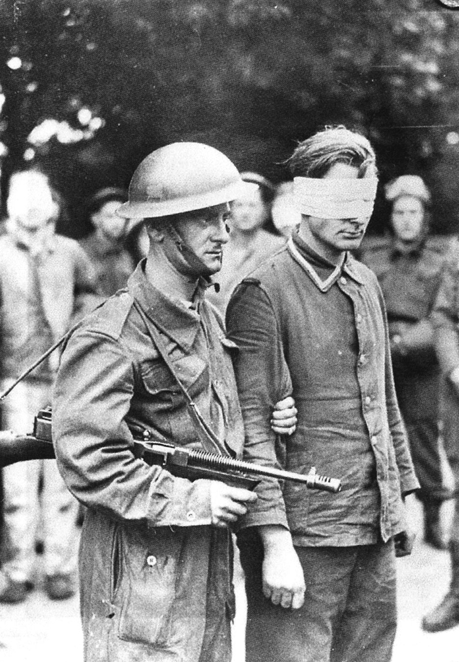 Canadian soldier armed with Thompson submachine gun guides German prisoner captured during Operation Jubilee (Library and Archives Canada)