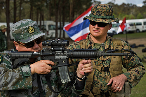 Marine watches as PLA soldier looks through optic of M4 carbine during Australian Army Skill at Arms Meeting in Puckapunyal, Australia (U.S. Air Force/Michael R. Holzworth)