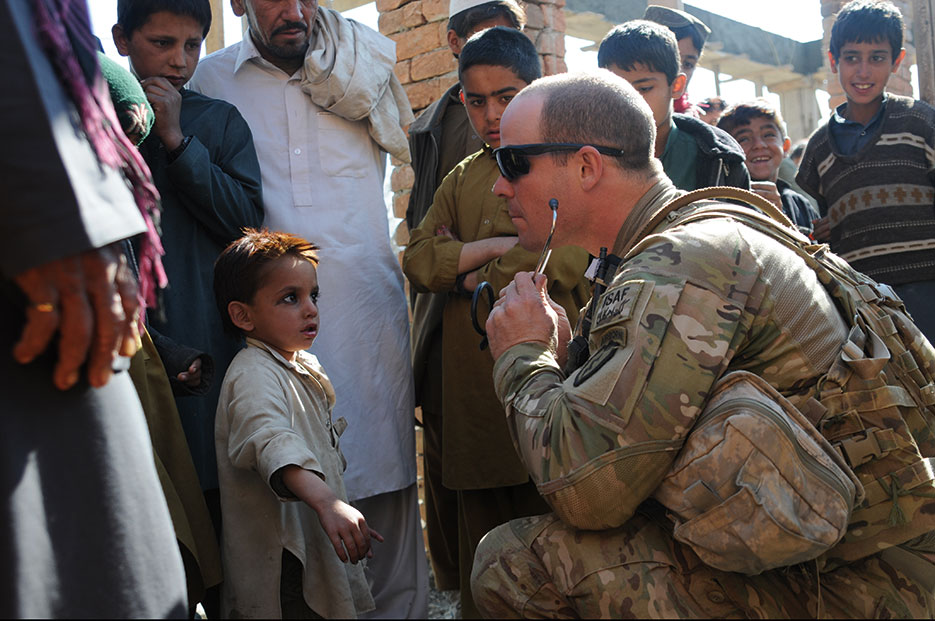 Medic conducts checks with Afghan children in Khowst Province (U.S. Army/Jason Epperson)
