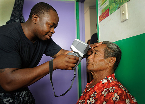 Corpsman uses auto refractor during eye examination at Prince Ngu Hospital in Tonga during Pacific Partnership 2011 (U.S. Navy/Eli J. Medellin)