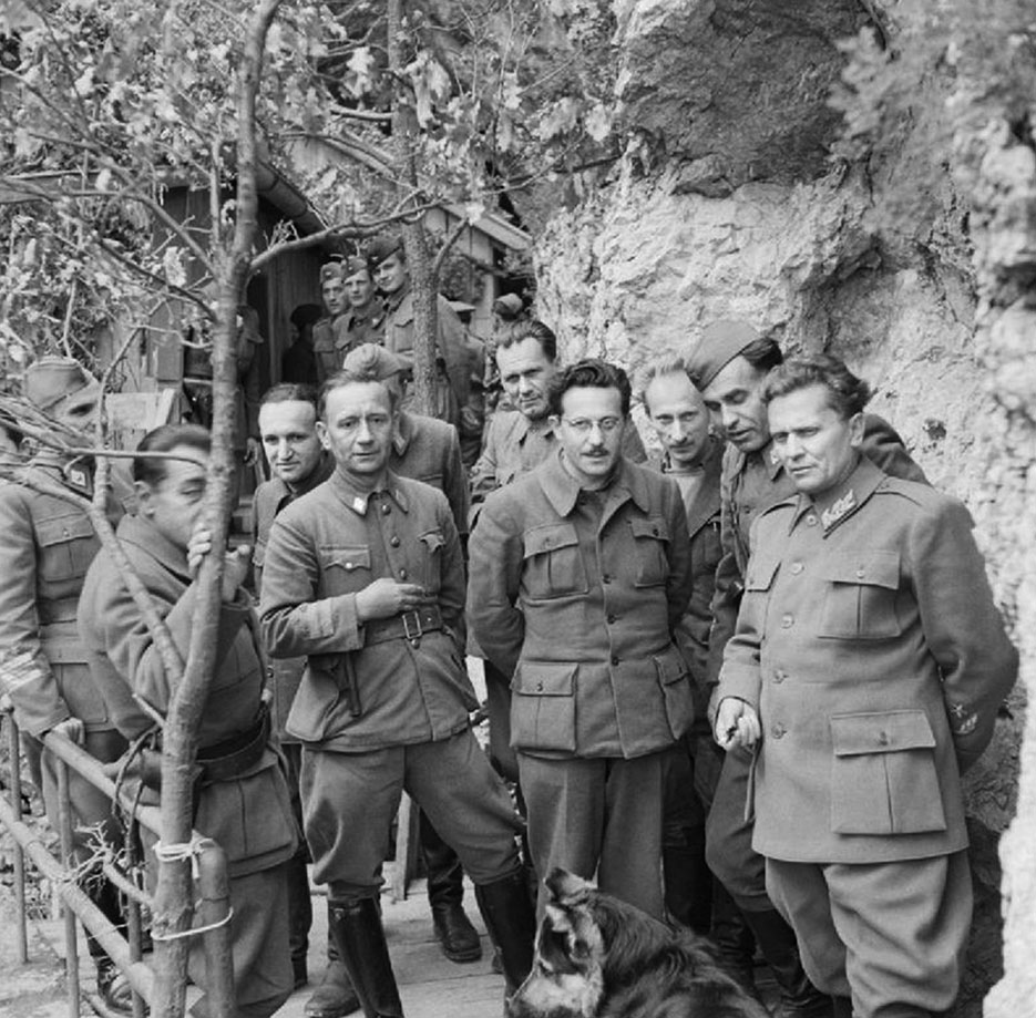 Marshal Josip Tito (right) stands with his Cabinet Ministers and Supreme Staff at his mountain headquarters in Yugoslavia on May 14, 1944 (Imperial War Museum)