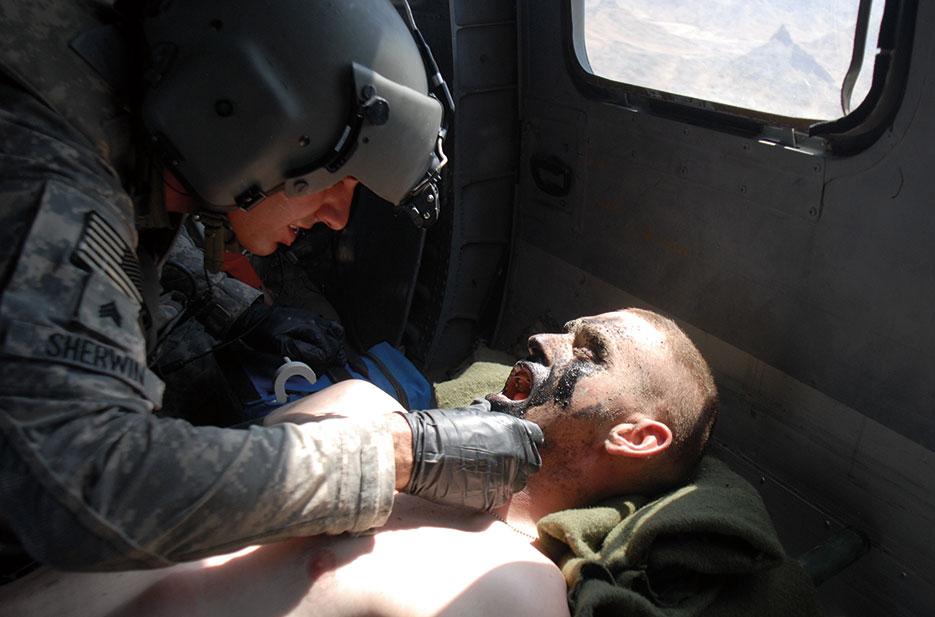 Flight medic treats Soldier from 1st Stryker Brigade Combat Team, 25th Infantry Division, while en route to Kandahar Airfield for additional treatment (DOD)
