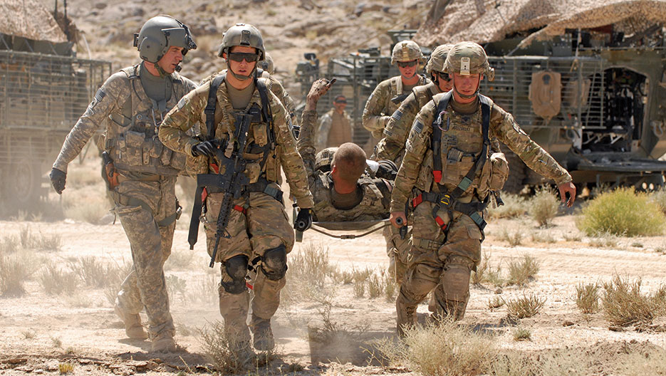 Soldier from 1st Stryker Brigade Combat Team, 25th Infantry Division, based in Fort Wainwright, Alaska, gives thumbs-up to members of his unit after being injured by roadside bomb in Kandahar Province (DOD/Haraz Ghanbari)