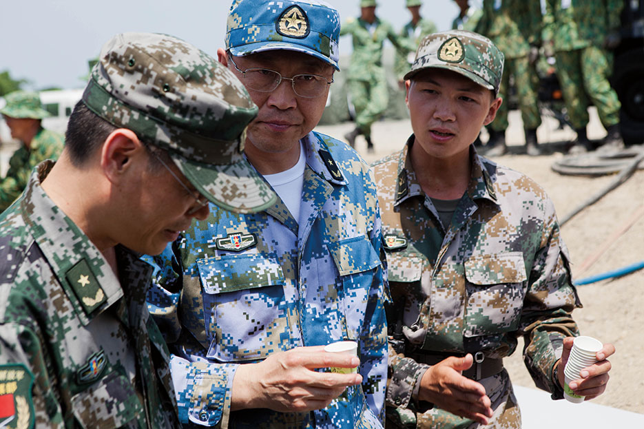 PLAN rear admiral drinks sample of purified water at disaster site in Biang, Brunei Darussalam, as engineers with China, Singapore, and the United States demonstrate water purification capabilities (U.S. Marines/Kasey Peacock)