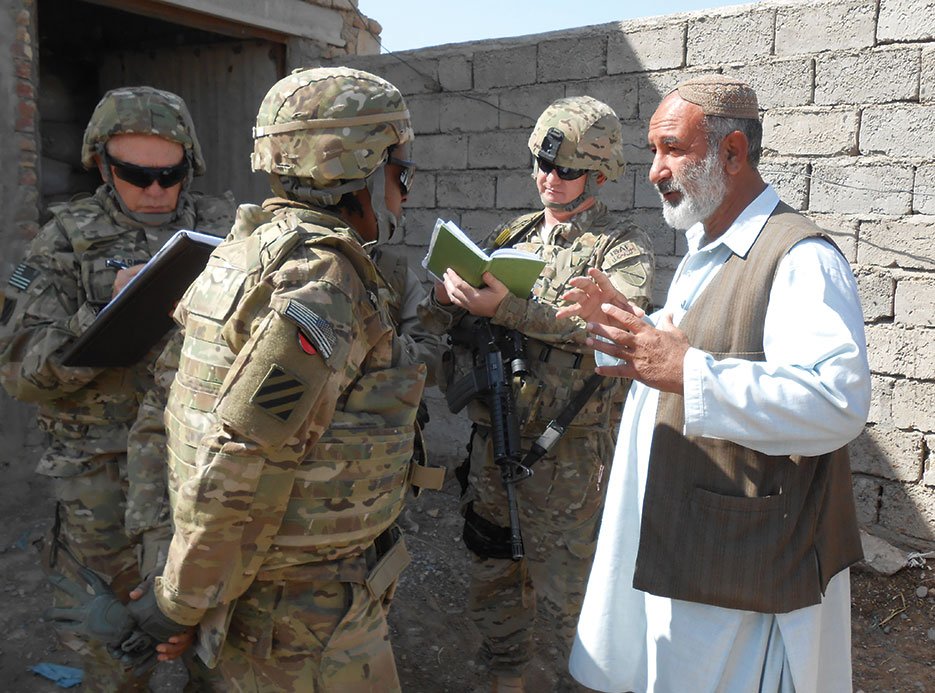 Civilian Expeditionary Workforce member engages local business owner in discussion regarding poultry feed production, Kandahar Province (Kentucky National Guard/Dallas Kratzer)