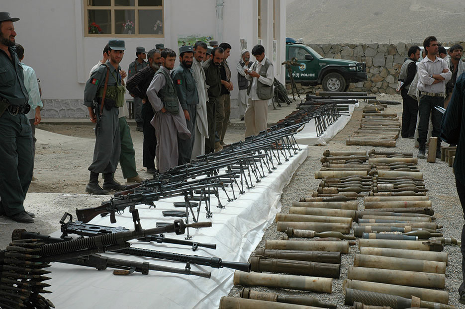 Local police, government leaders, and villagers gather outside new Anaba District Center in Panjshir Province, Afghanistan, August 11, 2008, to view weapons turned in through Disbandment of Illegal Armed Groups program (DOD/Jillian Torango)