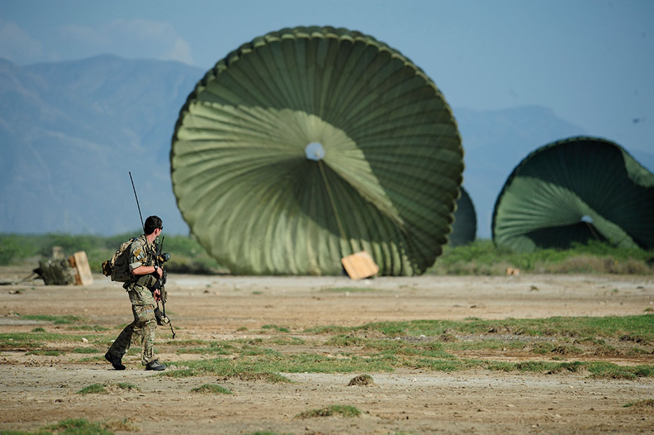 U.S. Air Force Combat Controller from 23rd Special Tactics Squadron, Air Force Special Operations Command, Hurlburt Field, Florida, watches pallets after airdrop of humanitarian aid for distribution in Port-au-Prince, Haiti, following magnitude 7 earthquake, January 18, 2010 (U.S. Air Force/James L. Harper, Jr.)