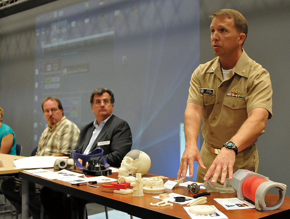 Captain Frank Futcher explains display of 3D-printed objects during Navy Warfare Development Command–sponsored innovation workshop at Old Dominion University in Norfolk, Virginia (U.S. Navy/Jonathan E. Donnelly)