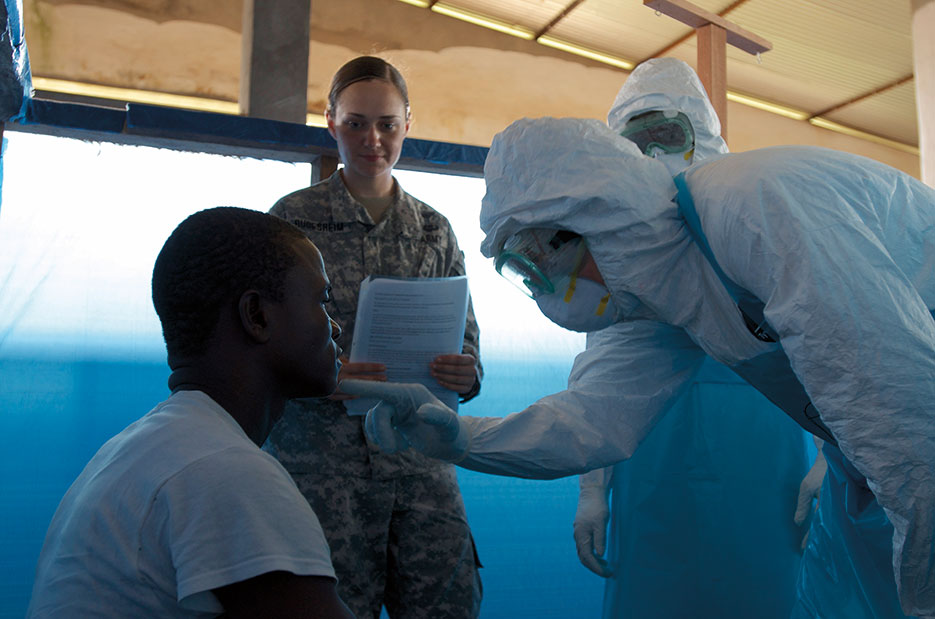 Students in Ebola Treatment Unit Course led by Joint Force Command–United Assistance, diagnose potential patient for symptoms of virus during scenario training, Monrovia, Liberia, November 20, 2014 (U.S. Army/V. Michelle Woods)