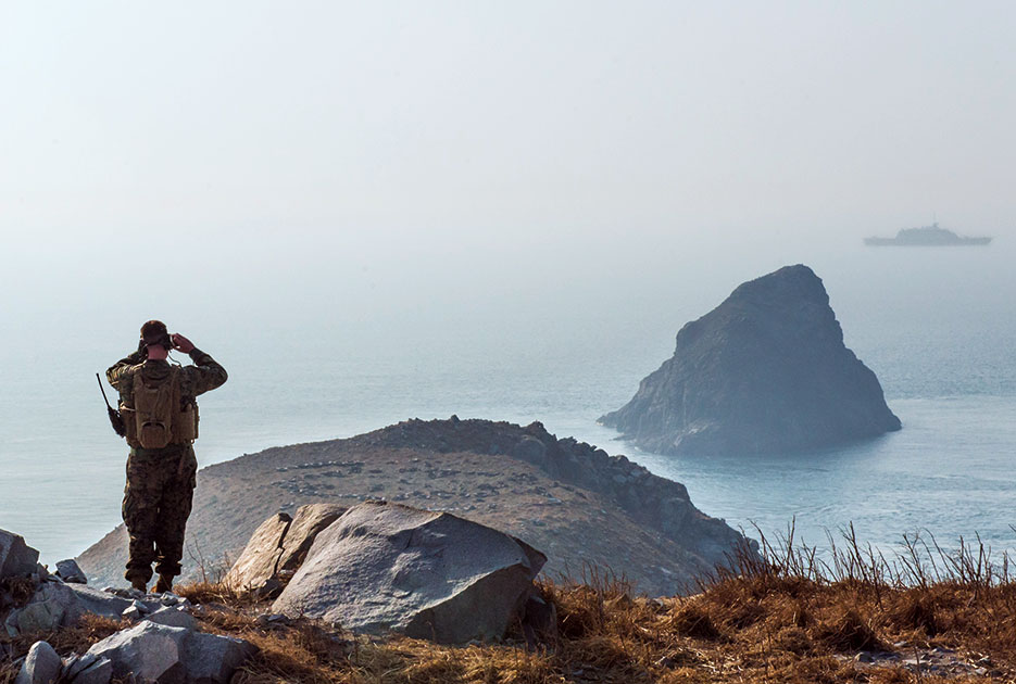 Marine currently embarked aboard littoral combat ship USS <i>Fort Worth</i> (LCS 3) performs sight survey on Jikdo Island, Republic of Korea, as part of training exercise during Foal Eagle 2015 (U.S. Navy/Conor Minto)