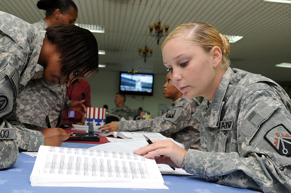 Soldier fills out absentee ballot form during voting assistance drive at Camp As Sayliyah, Qatar (U.S. Army/Dustin Senger)