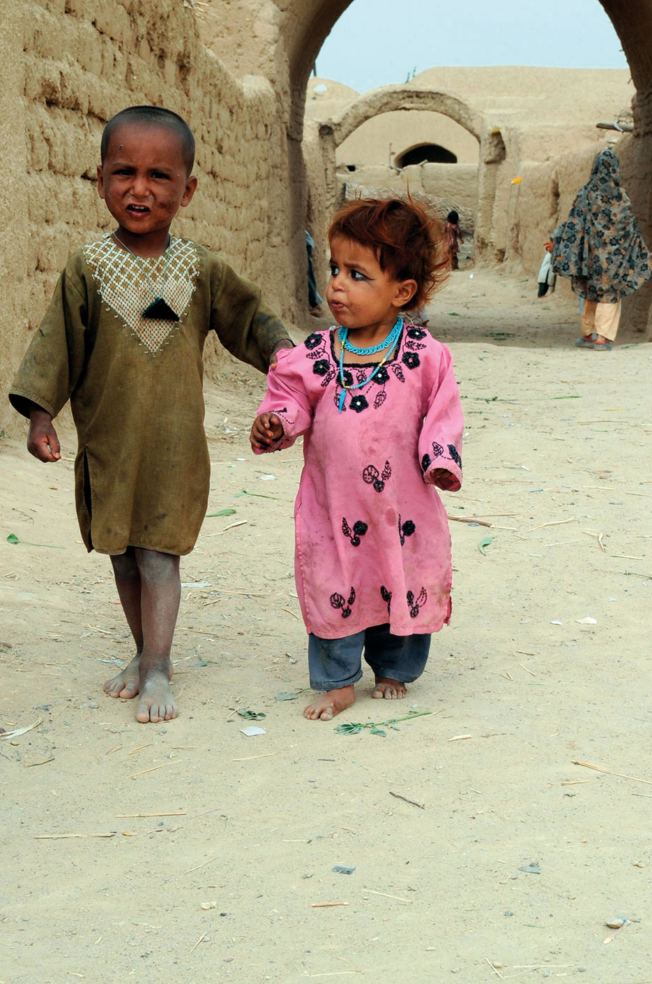 Afghan boy brings younger sister to receive toiletries given out by Afghan, Coalition, and U.S. Servicemembers assigned to Special Operations Task Force–West, near Mirmandab, Afghanistan, April 7, 2011 (DOD/Marcus Quarterman)