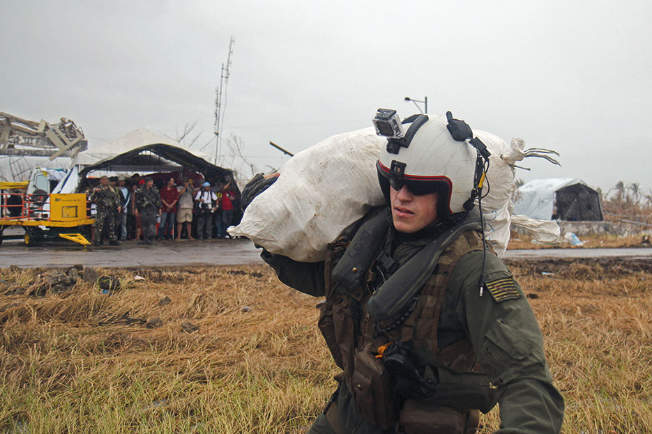 Sailor carries relief supplies to guided-missile cruiser USS Cowpens (CG 63) during Operation Damayan, November 16, 2013 (U.S. Navy/Ricardo R. Guzman)