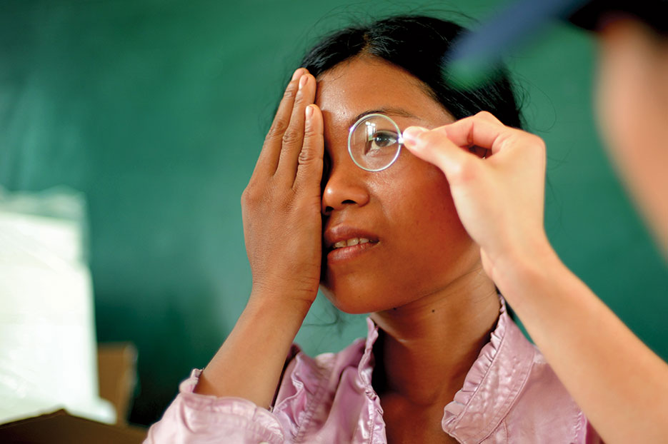 Patient looks through lens to determine eyeglass prescription during 2013 Operation Pacific Angel, Dong Hoi, Quang Binh Province, Vietnam (U.S. Air Force/Sara Csurilla)