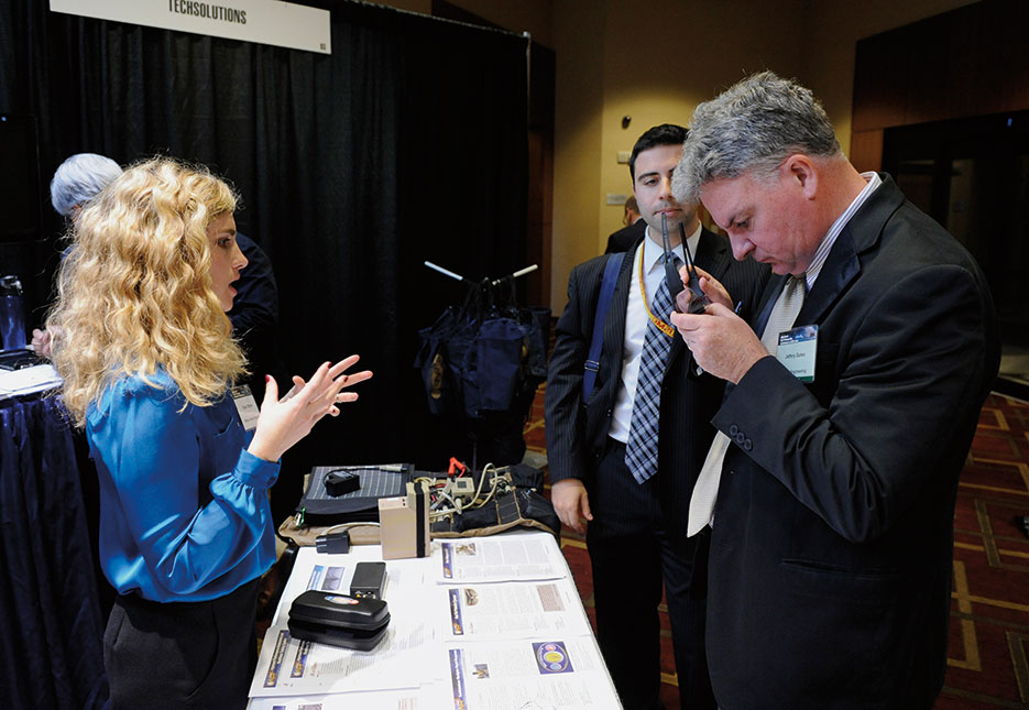 Dylan Ottman, from Office of Naval Research (ONR) Tech Solutions program, explains technology behind Fast-Tint Protective Eyewear during ONR 2012 Science and Technology Partnership Conference, Arlington, Virginia (U.S. Navy/John F. Williams)