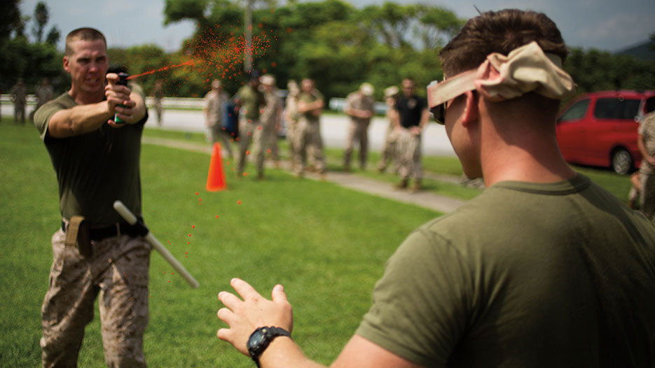 Instructor administers OC spray during OC Spray Performance Evaluation Course, part of Non-Lethal Weapons Instructor Course, on Camp Hansen, Okinawa, Japan, August 2015 (U.S. Marine Corps/Thor Larson)