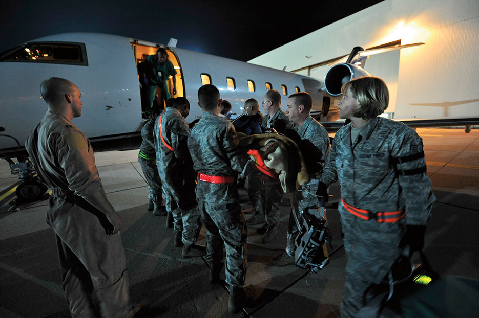 Airmen from 86th Aeromedical Evacuation Squadron and Critical Care Air Transport team from Landstuhl Regional Medical Center load wounded Libyan fighter onto civilian aircraft for transport to local German hospital, October 29, 2011, Ramstein Air Base, Germany (U.S. Air Force/Chenzira Mallory)