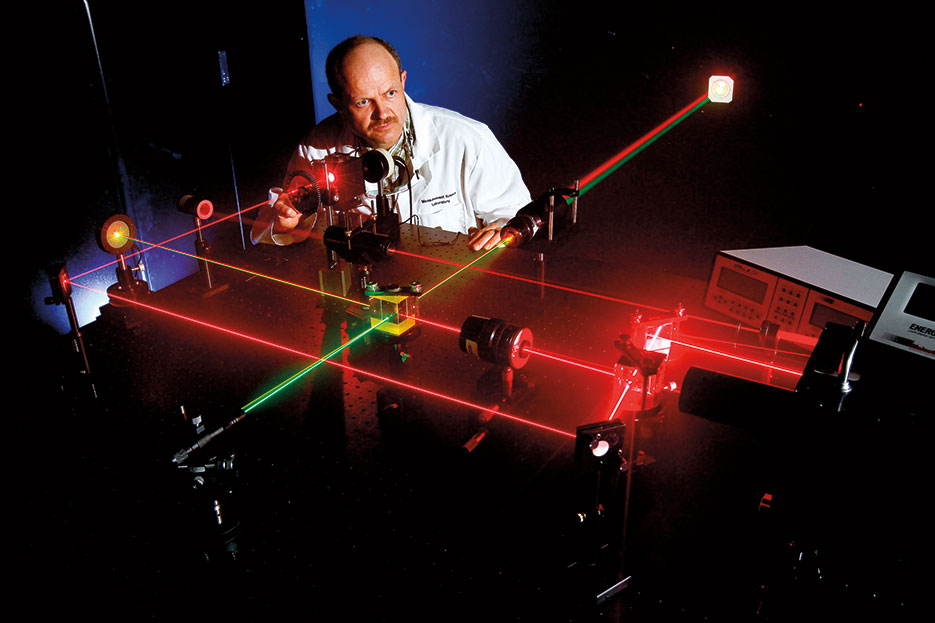 Microwave/Electro-Optic electronics engineer at Naval Surface Warfare Center, Corona Division, prepares alignment of various optical components using eye-safe visible lasers, Norco, California, April 19, 2011 (U.S. Navy/Greg Vojtko)