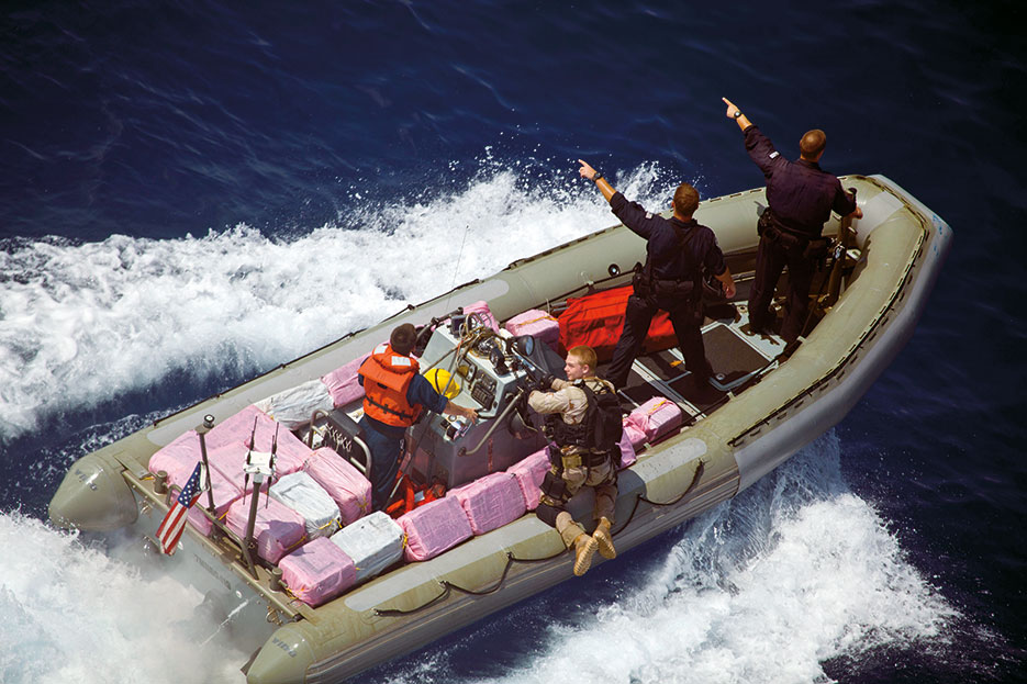 Navy and Coast Guard personnel assigned to guided-missile frigate USS Elrod signal toward narcotics bales, April 21, 2012, during recovery operations in Caribbean Sea (U.S. Army/Andy Barrera)