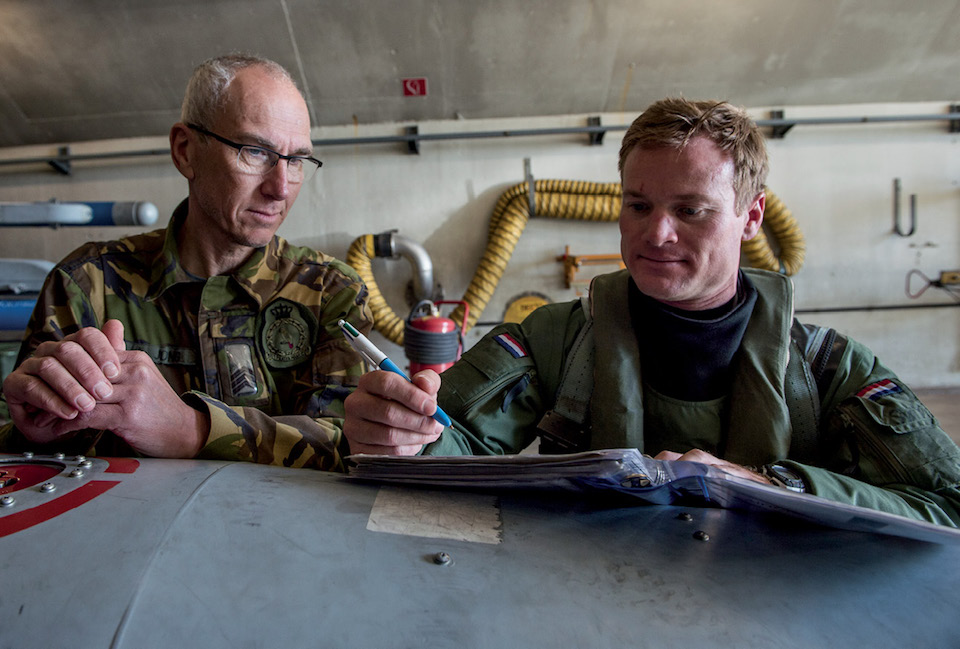 Dutch crew chief with 322nd Squadron (left) looks over flight records with U.S. Air Force Exchange Pilot at Leeuwarden Air Base, Netherlands, during NATO air forces’ Frisian Flag training exercise, March 27, 2017 (U.S. Air Force/Brian Ferguson)