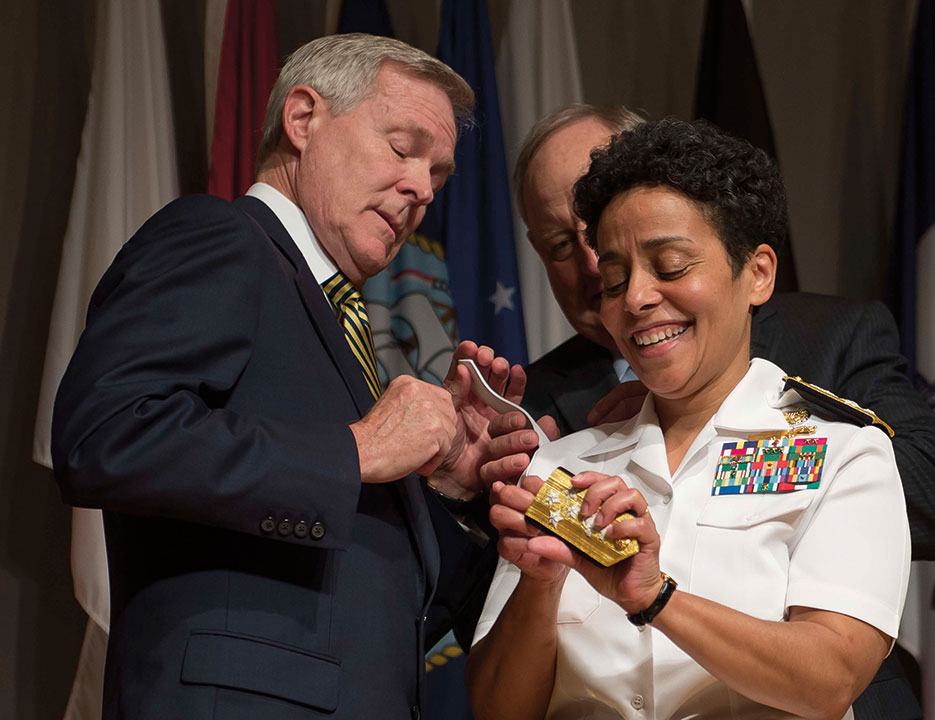 Admiral Michelle Howard lends a hand to Secretary of the Navy Ray Mabus as he and Wayne Cowles, Howard’s husband, put four-star shoulder boards on her Service white uniform during promotion ceremony at the Women in Military Service for America Memorial. Howard is the first woman to be promoted to the rank of admiral in the history of the Navy (U.S. Navy/Peter D. Lawlor)