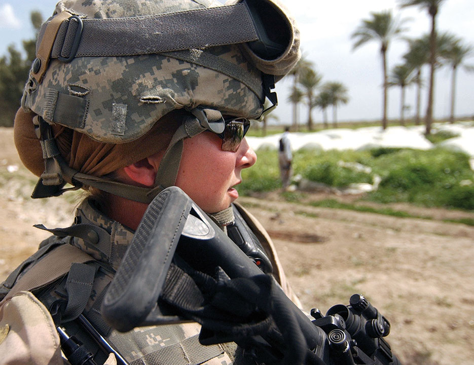 Sergeant Ashley Hort, USA, keeps weapon at ready as she provides security for fellow Soldiers during raid in Al Haswah, Iraq, March 2007 (DOD/Olanrewaju Akinwunmi)