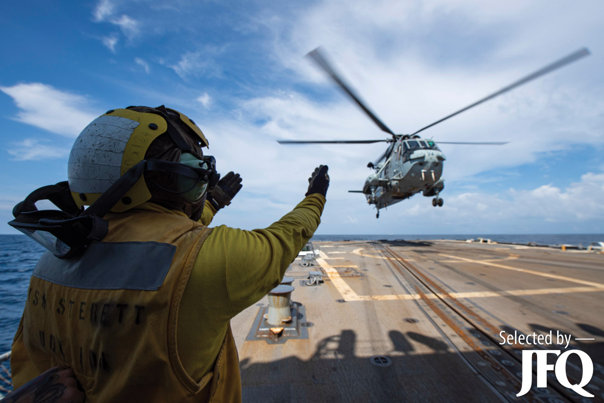 Boatswain’s Mate directs Indian Navy Sea King Mk42B helicopter into position
