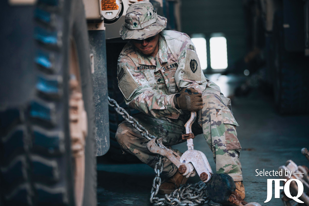 Soldier secures truck to deck of USAV General Brehon B. Somervell before setting sail