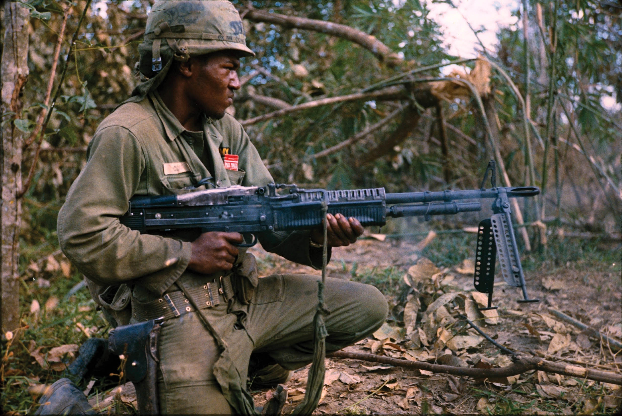 Private First Class Milton L. Cook, from Company C, 1st Battalion, 5th Mechanized Infantry, 25th Infantry Division, fires M60 machine gun while on search and destroy mission as part of Operation Cedar Falls, conducted in and around Filhol Plantation near Cu Chi, Republic of Vietnam, January 8, 1967 (U.S. National Archives and Records Administration)