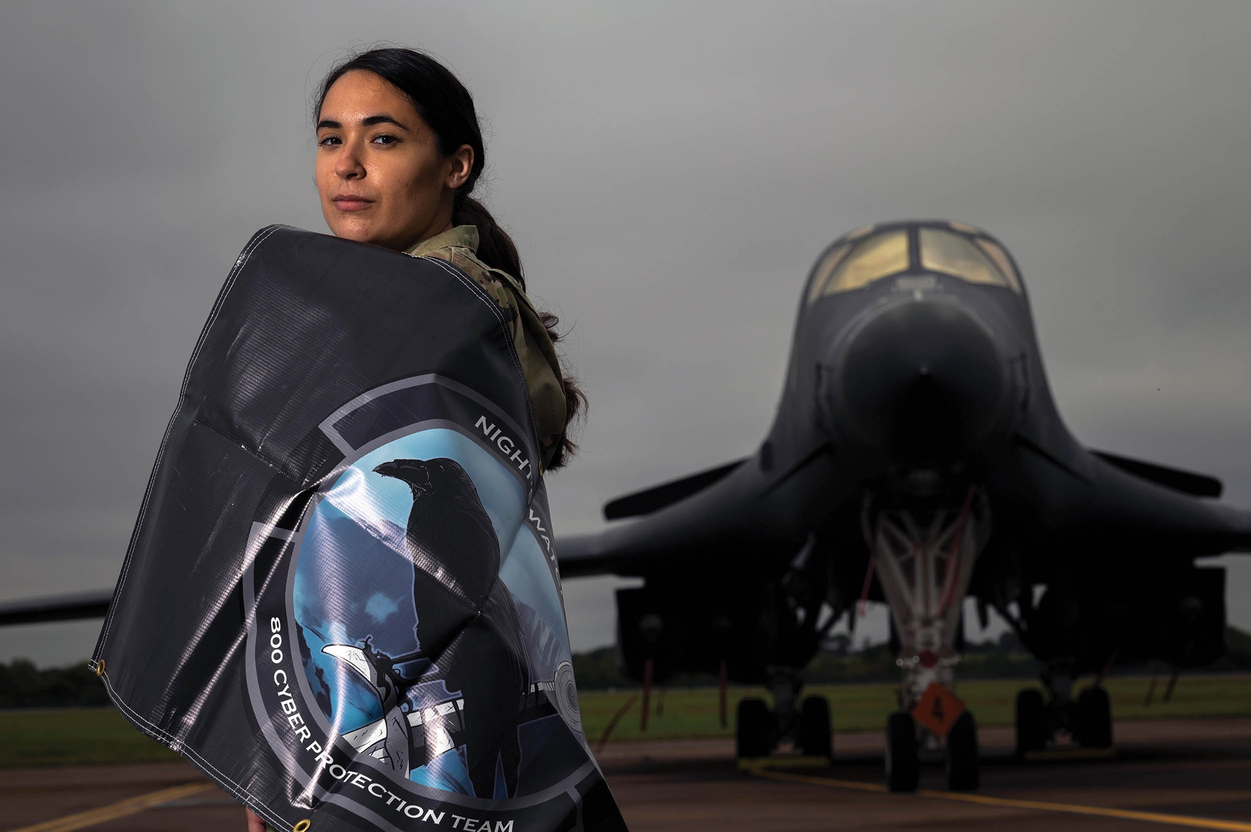 Cyber crew lead assigned to 800th Cyber Protection Team, Joint Force Headquarters Cyber–Air Force, poses for photo in front of 9th Expeditionary Bomb Squadron B-1B Lancer at Royal Air Force Fairford, United Kingdom, October 8, 2021 (U.S. Air Force/Colin Hollowell)