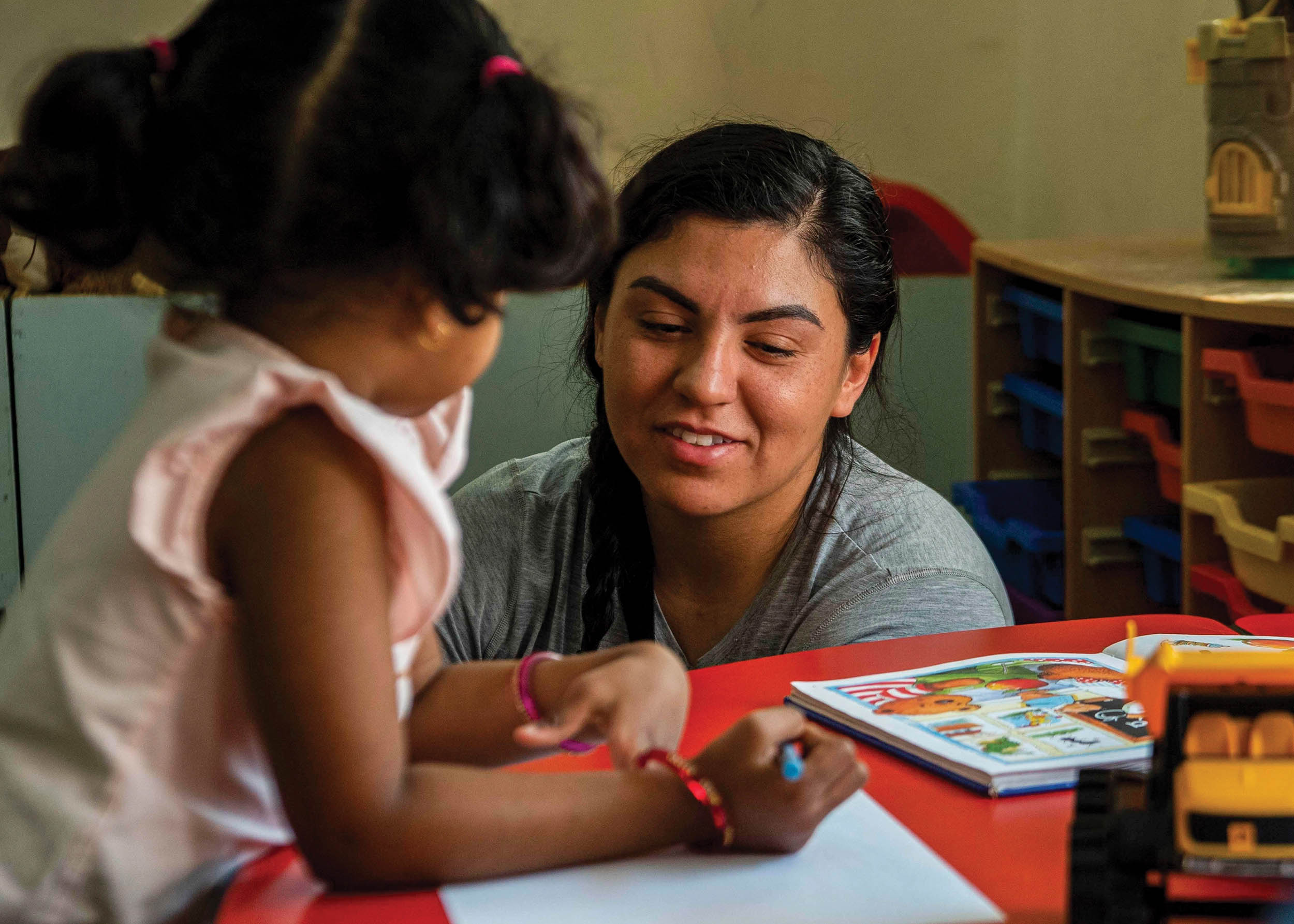 Aircrew Survival Equipmentman 2nd Class Sonia Aquino, assigned to guided-missile destroyer USS Gridley, talks to child from Rehabilitation Institute for Autism during community service event in Manama, Bahrain, April 6, 2022 (U.S. Navy/Colby A. Mothershead)