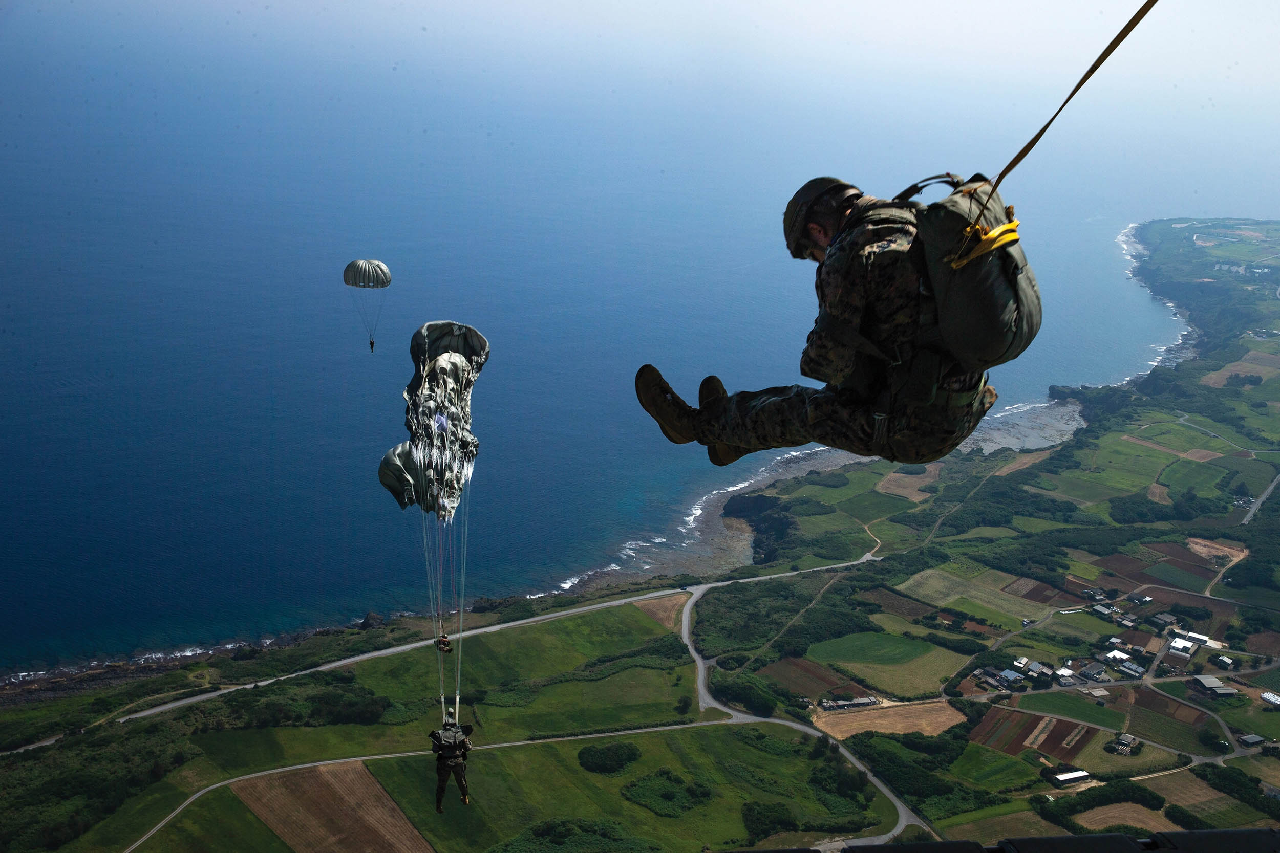 Marines with 3rd Reconnaissance Battalion jump from KC-130J Super Hercules assigned to Marine Aerial Refueler Transport Squadron 152, Marine Aircraft Wing 36, during military free fall and low-level static line parachute operations over Ie Shima, Okinawa, Japan, May 16, 2023 (U.S. Marine Corps/Michael Taggart)