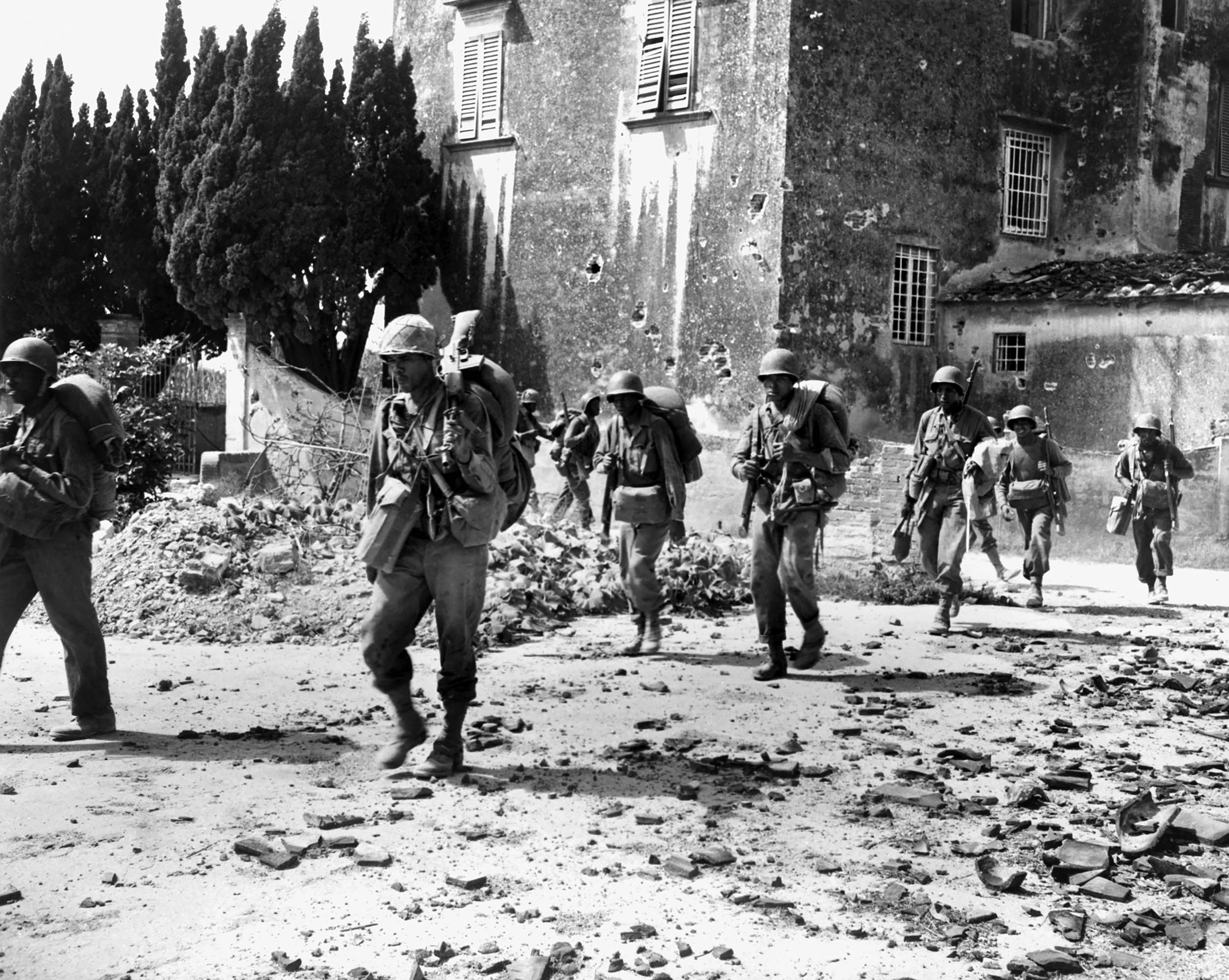 Combat Soldiers on patrol near bombed buildings, somewhere in Europe, 1944 (Everett Collection/Alamy)