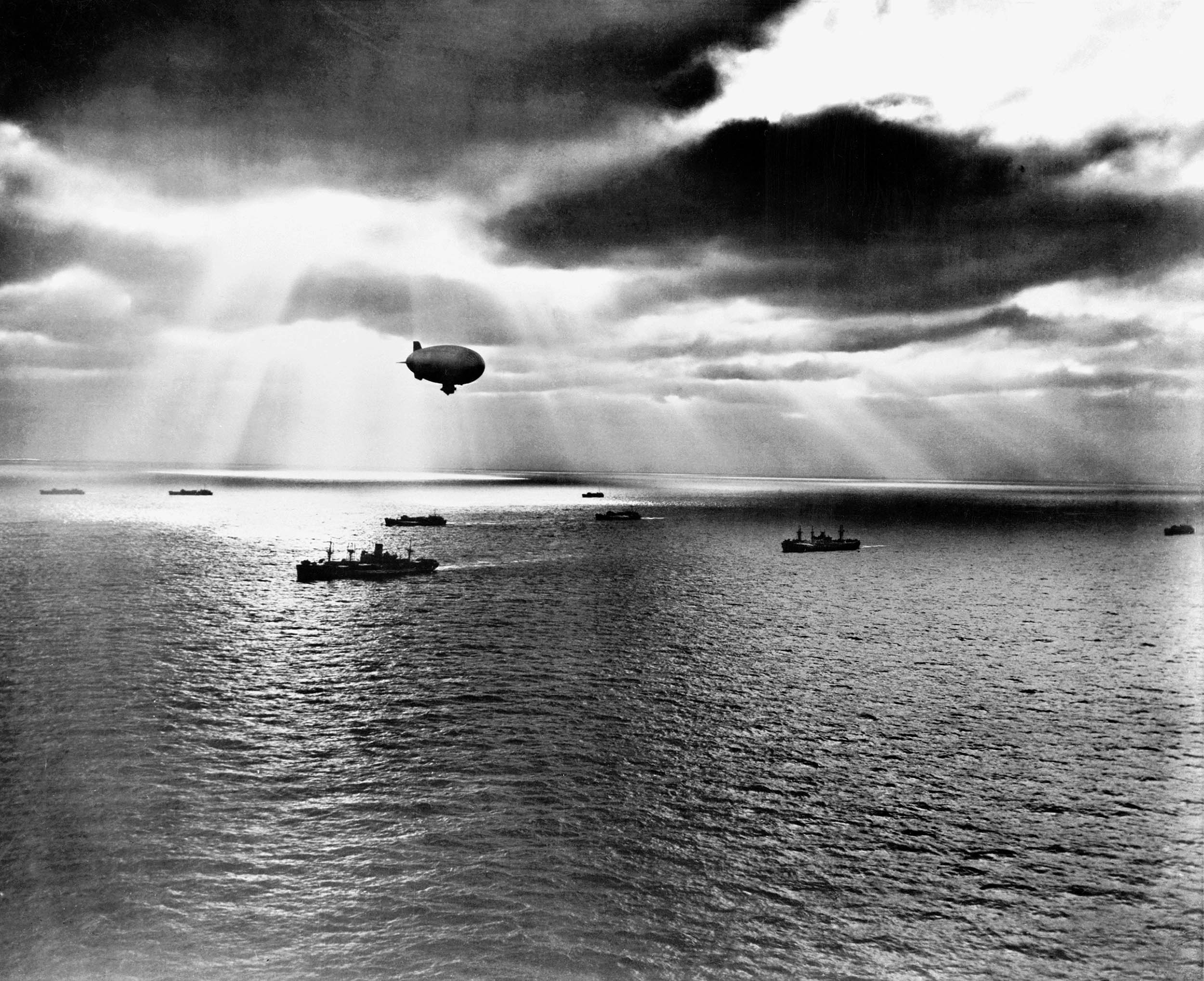 Allied convoy in Atlantic Ocean moves toward its destination while Navy K-class lighter-than-air aircraft hovers overhead, watching for enemy
U-Boats, June 1943 (National Museum of the U.S. Navy)