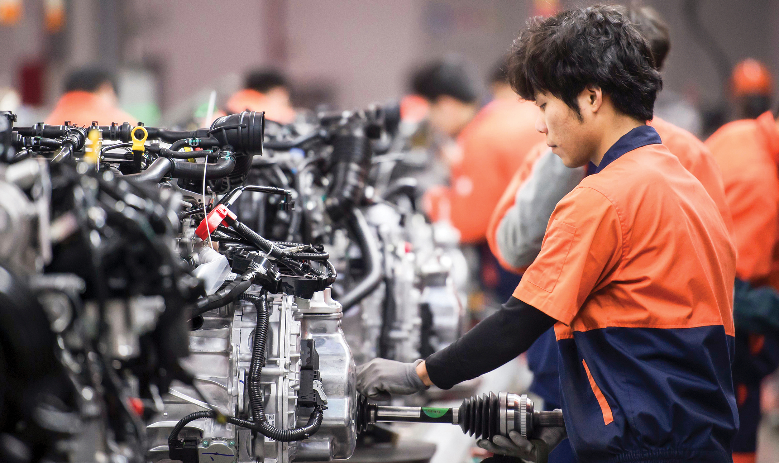 Assembly plant workers assemble engines at Geely Automobile Manufacturing Plant
