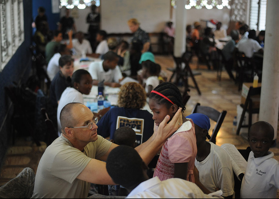 Air Force major examines patient at temporary medical site at Killick Haitian Coast Guard Base in Port-au-Prince, Haiti, during Continuing Promise 2011 (U.S. Navy/Eric C. Tretter)