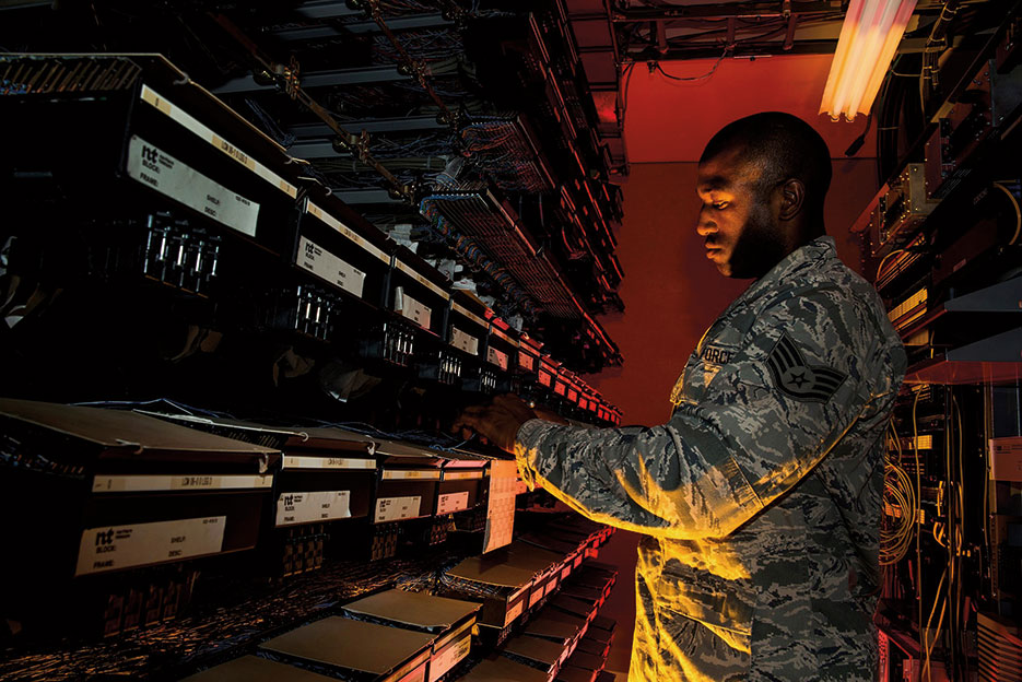 Airman maintains communications cabling including copper wiring, indoor and outdoor cabling, and telephone switches (U.S. Air Force/George Goslin)