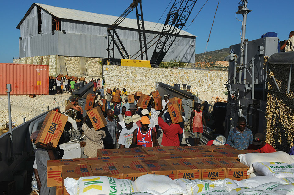 Citizens unload relief supplies in Gonaives, Haiti, from landing craft utility embarked on USS Kearsarge (U.S. Navy/Joshua Adam Nuzzo)
