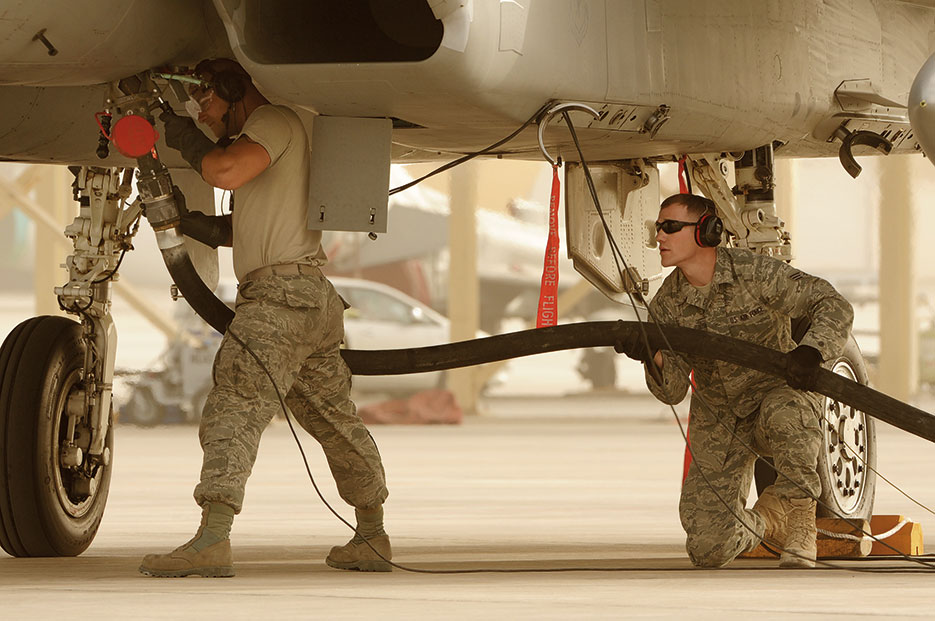 Airmen from 380th Expeditionary Logistics Readiness Squadron hold pump under F-15 Eagle aircraft for hot-pit refueling in southwest Asia, March 2012, (U.S. Air Force/Arian Nead)