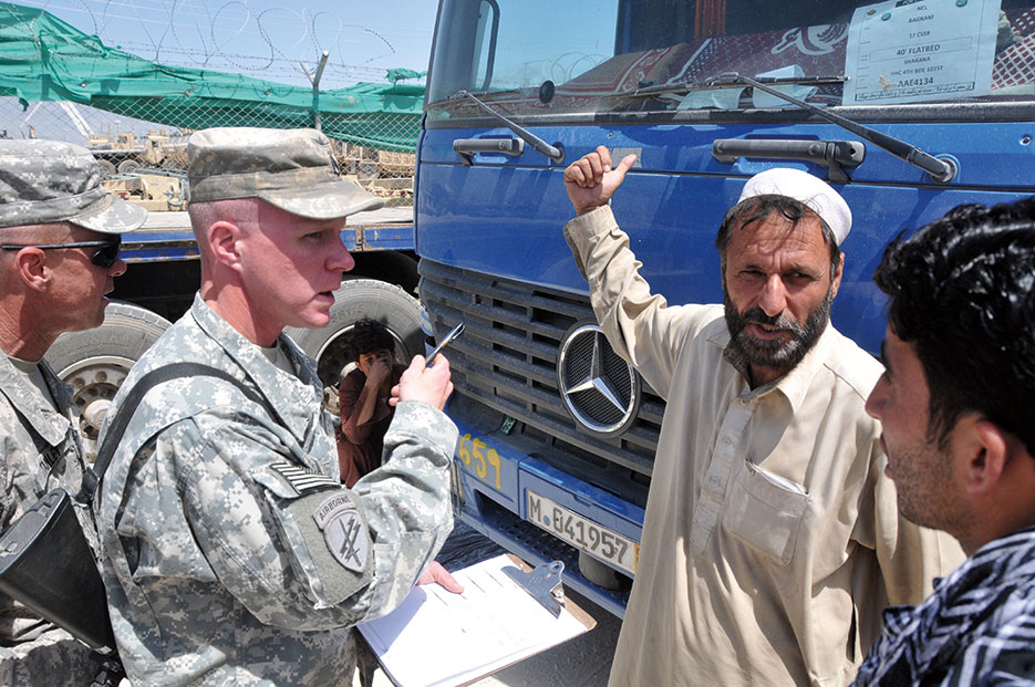 Anti-corruption interview team from 101st Sustainment Brigade talk with local trucker about conditions on road (U.S. Army/Peter Mayes)