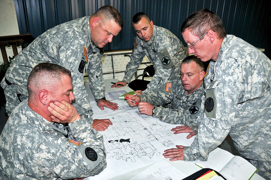 Command element from Arkansas Army National Guard’s 142nd Fires Brigade looks over map of Woodruff County in eastern Arkansas in effort to deploy troops in support of evacuation operations due to flooding (DOD/Chris Durney)