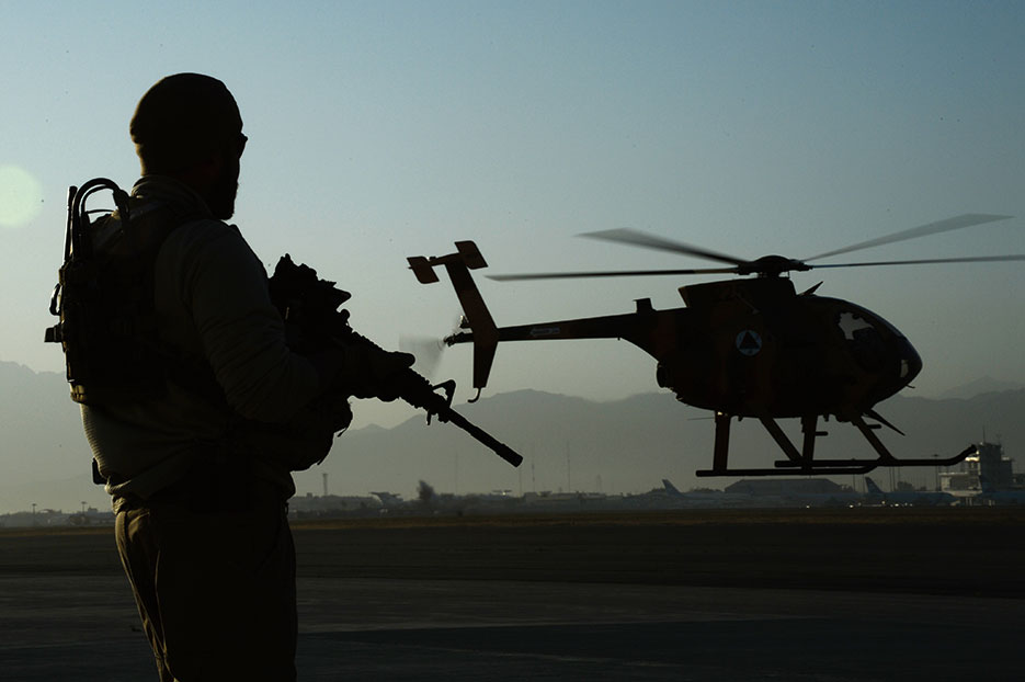 U.S. Army Train, Advise, Assist Command–Air personal security detail shift lead provides security while MD-530 Cayuse Warrior takes off with all-Afghan crew for combat mission, September 27, 2015 (U.S. Air Force/Sandra Welch)